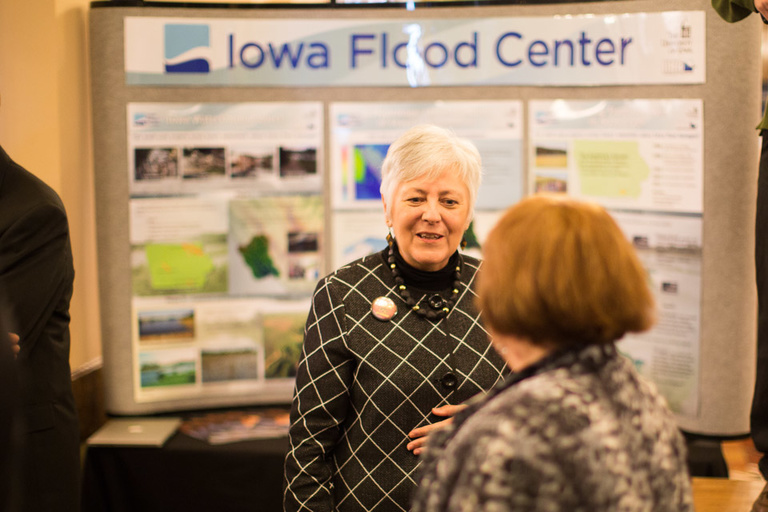 Sally Mason in front of Iowa Flood Center poster.