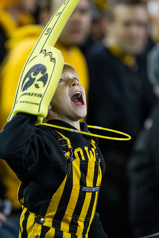 A cheering kid wearing a foam finger.