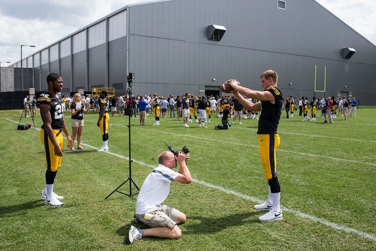 A photographer taking a portrait of a football player.