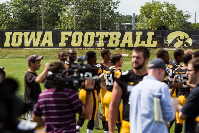 A sign in the background reading Iowa Football.