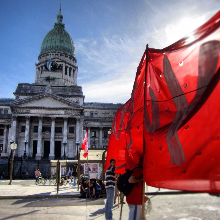 People gather in the Plaza de Mayo in Buenos Aires, putting up flags during the day of remembrance for truth and justice to recognize the thousands who were killed in the Dirty War.