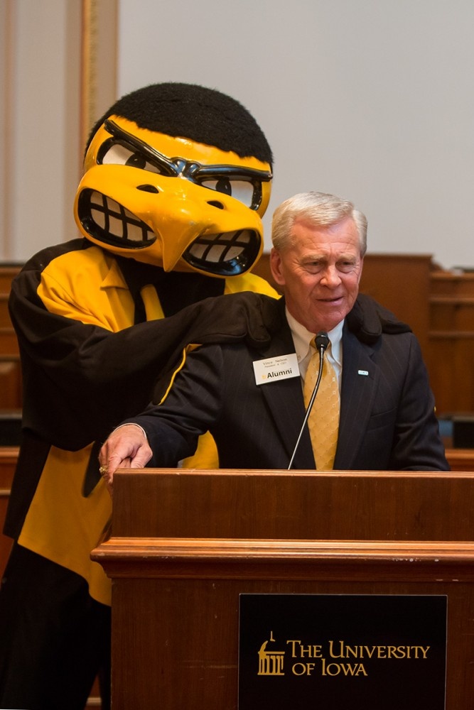 UI Alumni Association President Vince Nelson gets a surprise visit from Herky during his opening remarks at the Hawkeye Caucus.