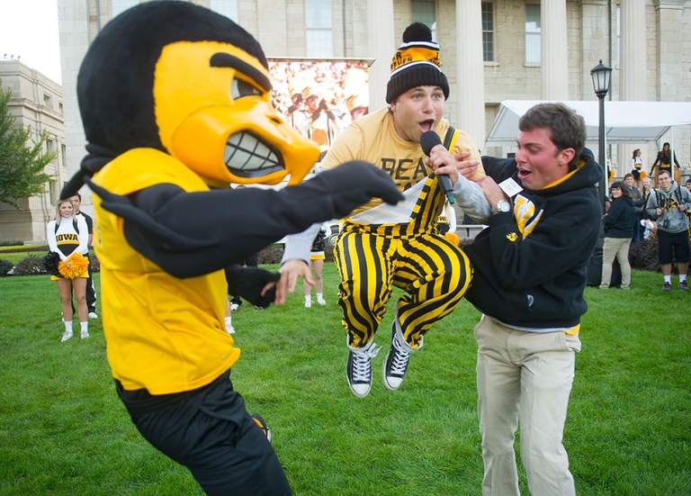 Man in black and gold striped overalls jumping.