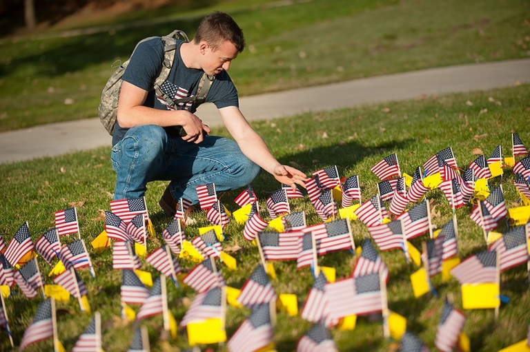 A veteran looks at the flags on the Pentacrest