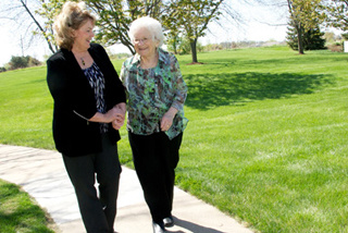 Karen Arthur and Alma Olson walk along a path