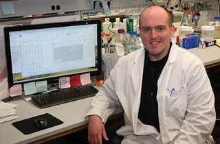 Andrew Shepherd next to a computer in lab setting