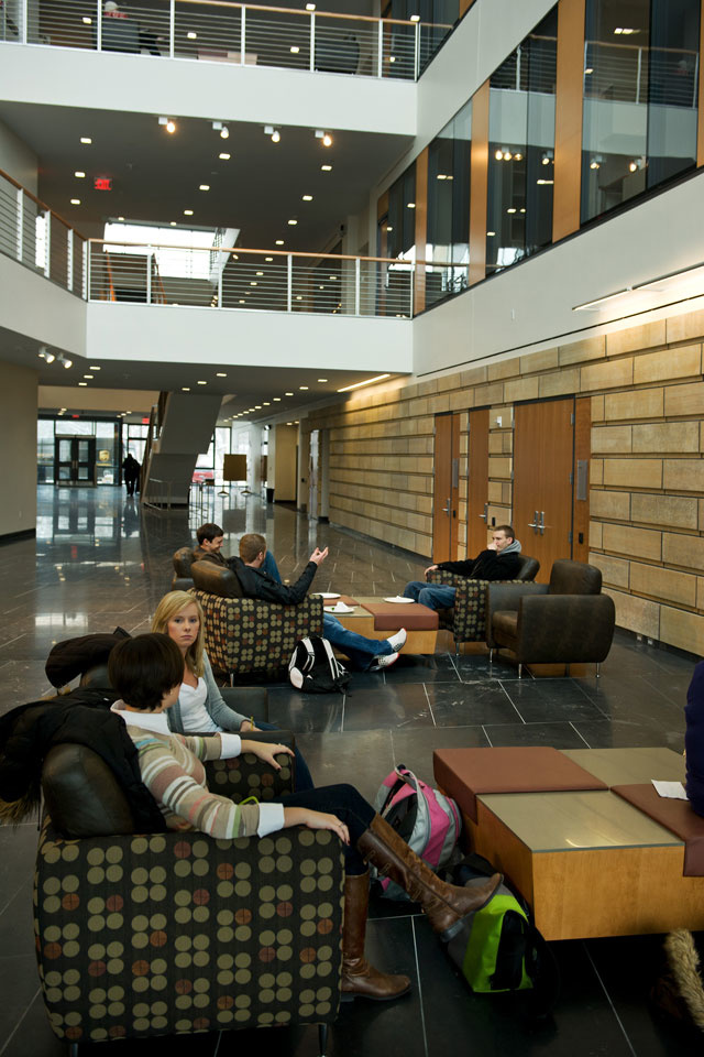 Students sit and visit in a seating area.