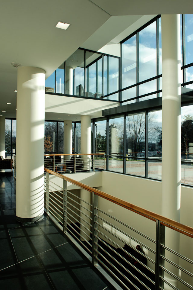 Architectural interior view showing large columns and large window walls.