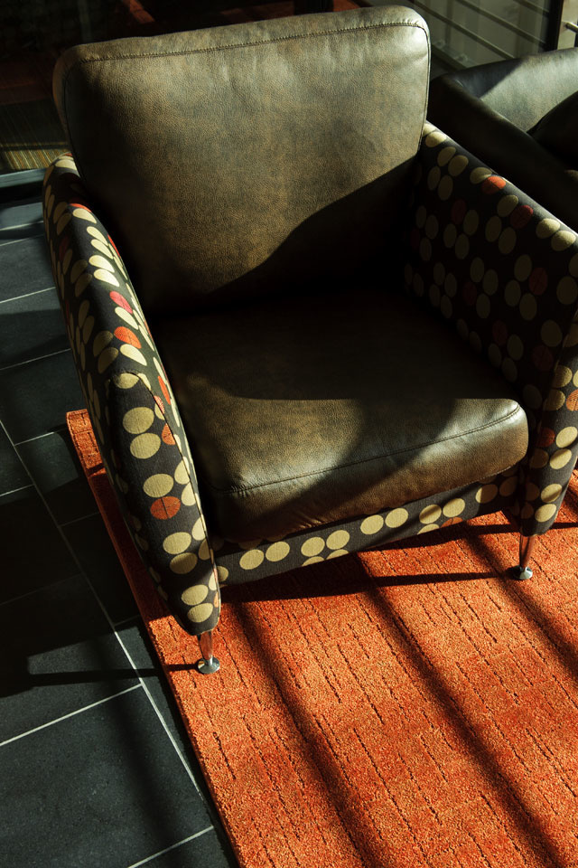 A leather chair sits on a brightly colored carpet.