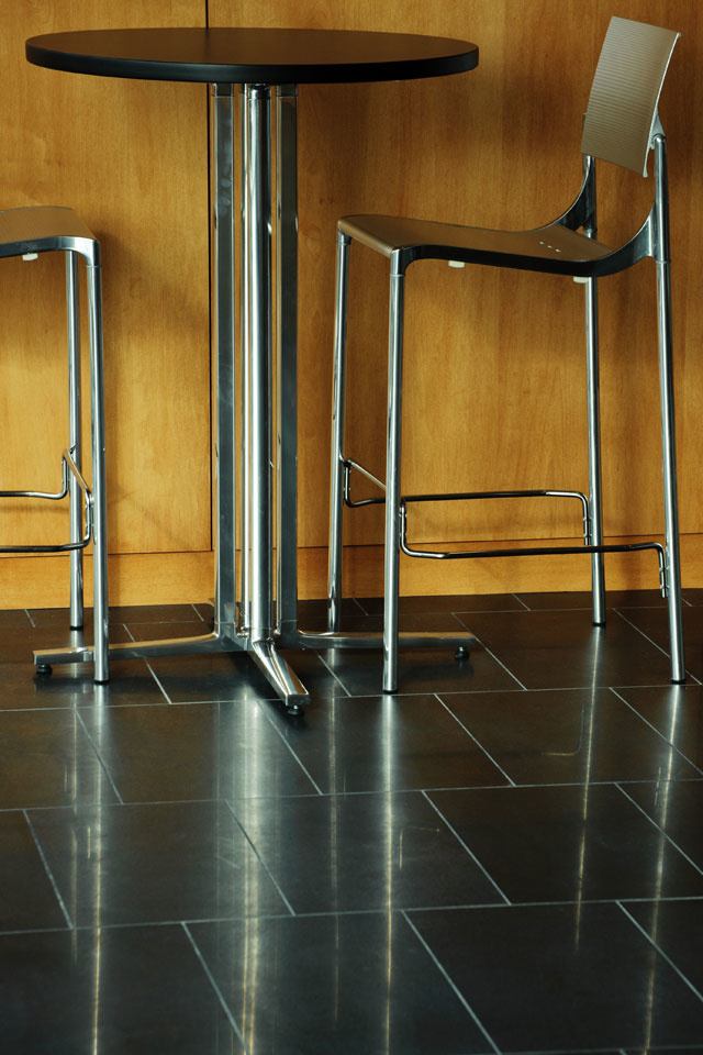 Metal furniture legs reflect off polished slate floors.