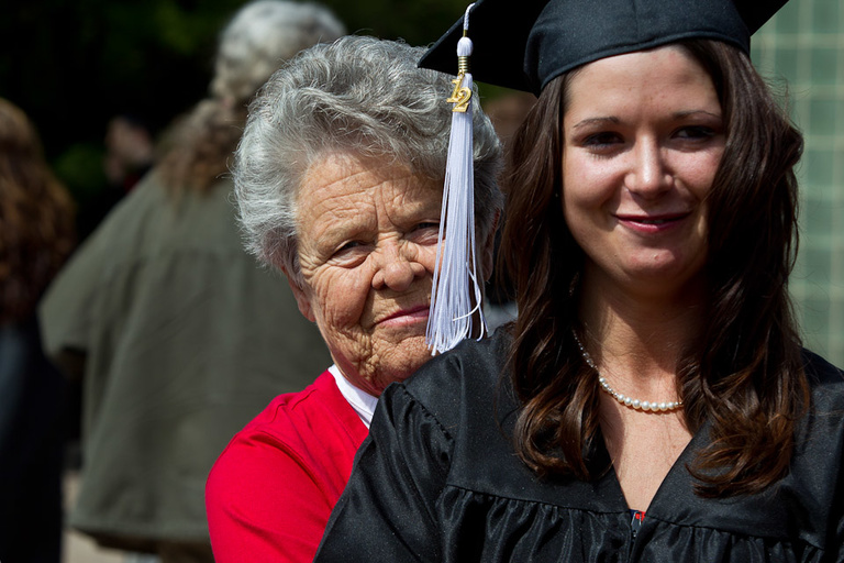A grandmother stands behind a UI graduate