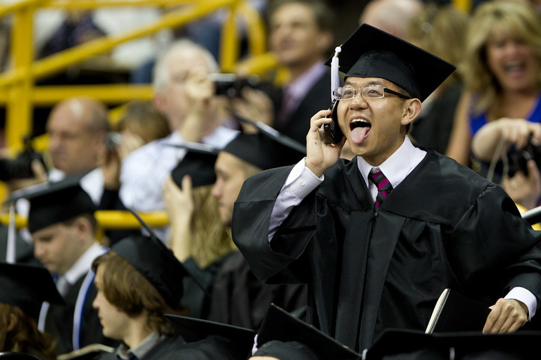 UI graduate sticks out his tongue in excitement at commencement.