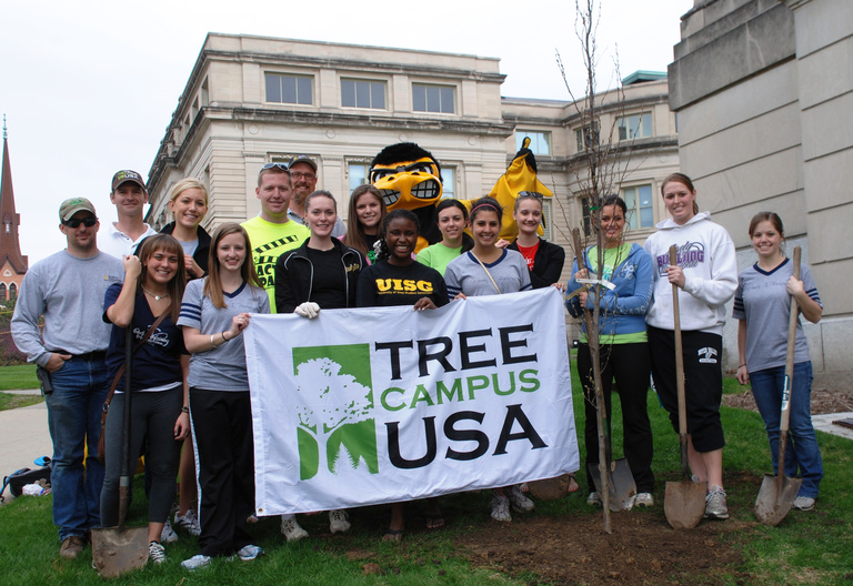 Herky helps Landscape Services staff and UI students plant trees on the Pentacrest