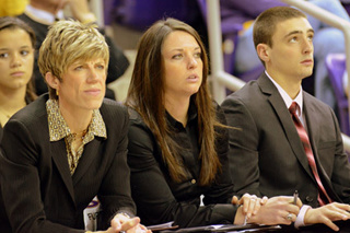 Abby Emmert (center) sits courtside at a UI women's basketball game