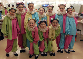 10 young gilrls dressed as clowns in a dressing room