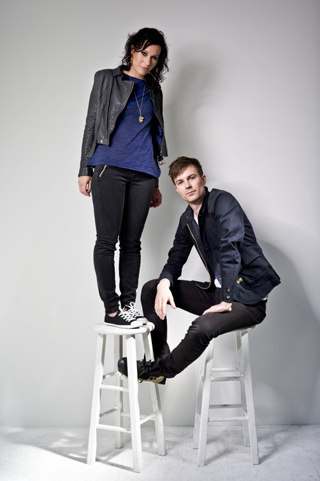 woman standing on a stool next to man sitting on a stool