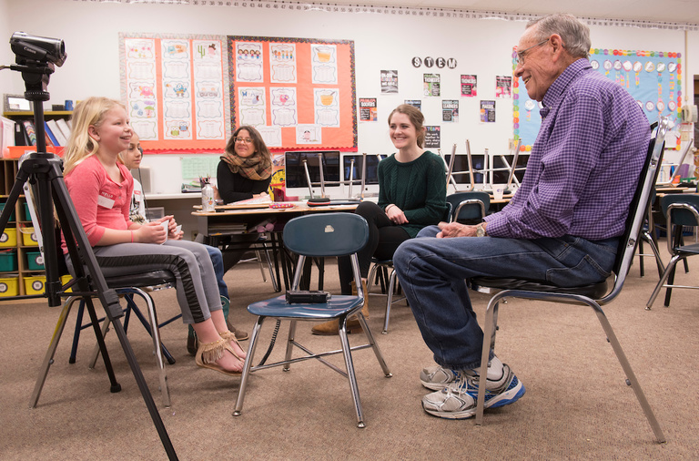 elementary students interview an older gentleman