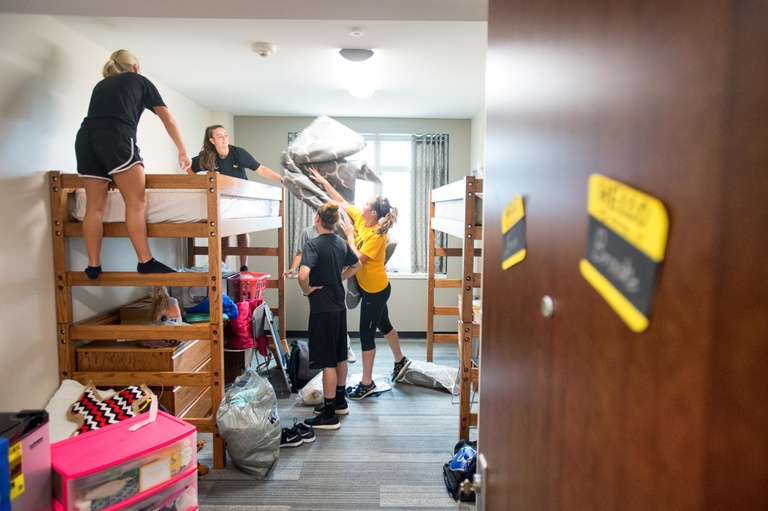 A first-year student and her teammates help move into her room