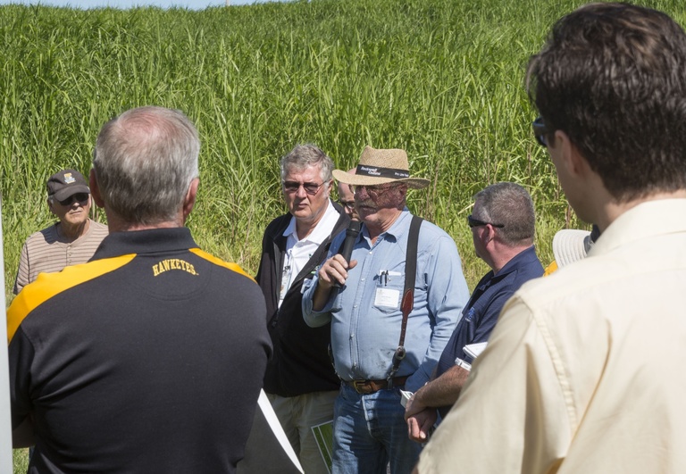 Farmer holding a mic at a tour of a Miscanthus field