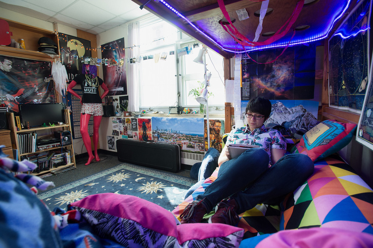 Student reading on couch in decorated dorm room