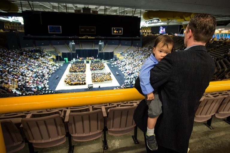 man holding child at commencement