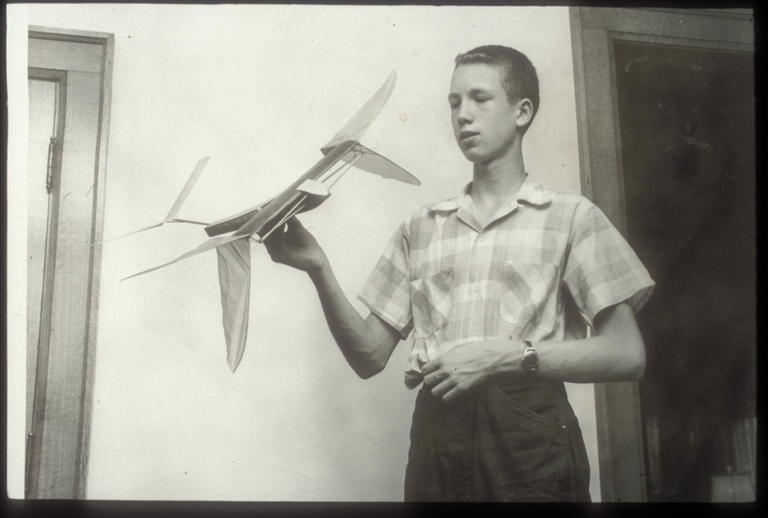 Don Gurnett poses in 1956 with a rubber band-powered model ornithopter that he designed and built. This model set a national record for the longest time in flight in 1956.