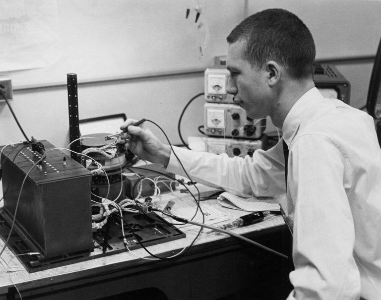 Don Gurnett performs voltage checks on a spacecraft battery in 1961.