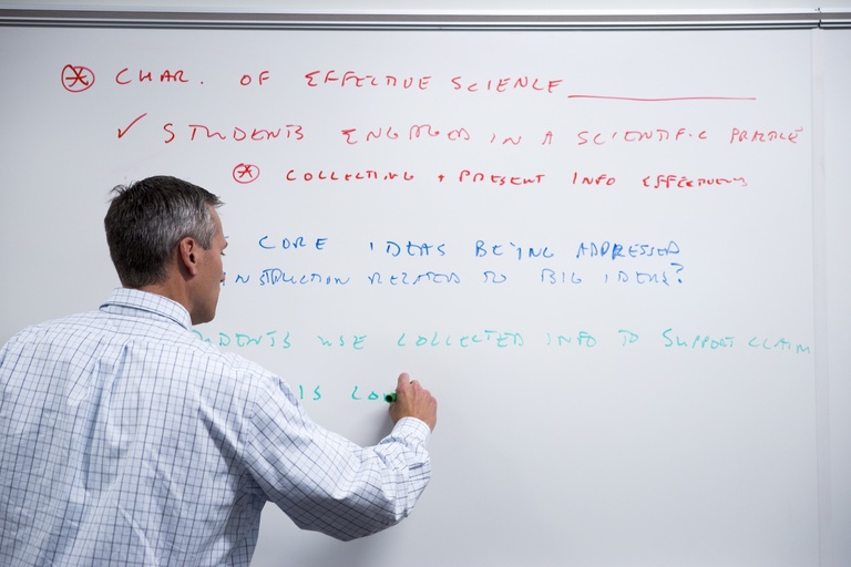 McDermott writes in different colors on a white board.