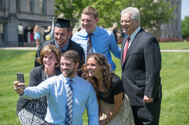 Graduates and their families celebrating commencement on the Pentacrest