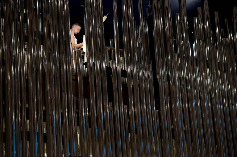 Silvery organ pipes framing worker