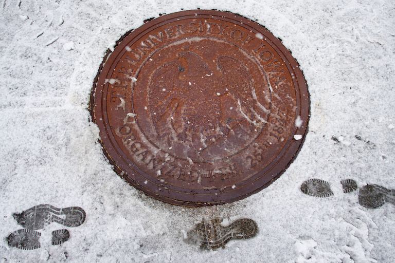 Footprints in snow next to manhole cover with UI seal