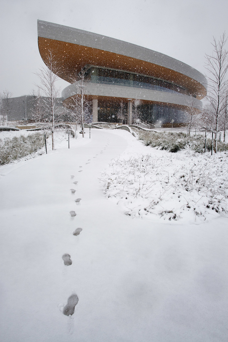 Footprints in snow leading up to Hancher Auditorium