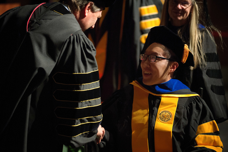 A student receives his degree at the University of Iowa Graduate College commencement ceremony on Dec. 16. About 250 students received their degrees at the ceremony.