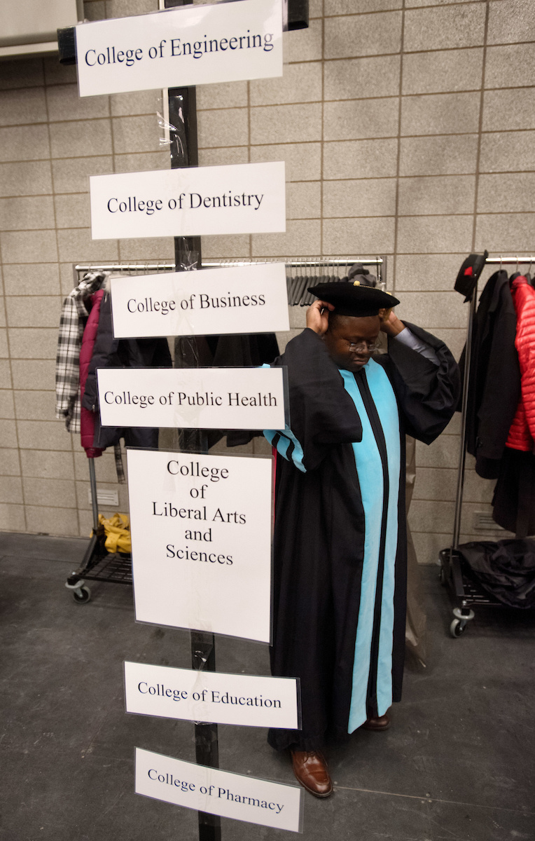 A student readies himself before the University of Iowa Graduate College commencement ceremony on Dec. 16. About 250 students received degrees at the ceremony.