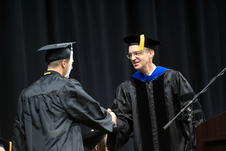 University of Iowa Provost P. Barry Butler congratulates a student during the College of Liberal Arts and Sciences and University College commencement ceremony on Dec. 17 at Carver-Hawkeye Arena. About 790 students received degrees during the ceremony.