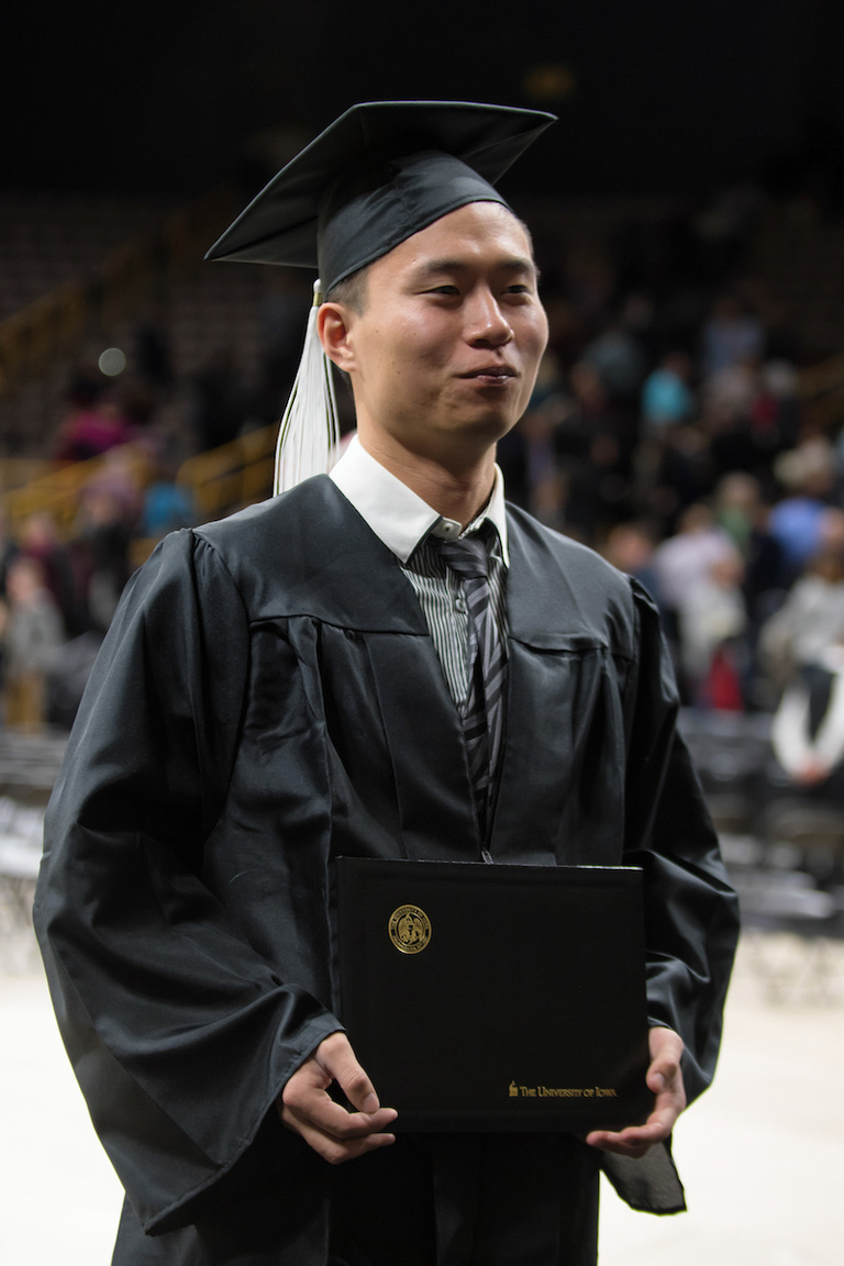 A student poses for a photo with his diploma at the University of Iowa College of Liberal Arts and Sciences and University College commencement ceremony Dec. 17 at Carver-Hawkeye Arena. About 790 students received degrees during the ceremony.