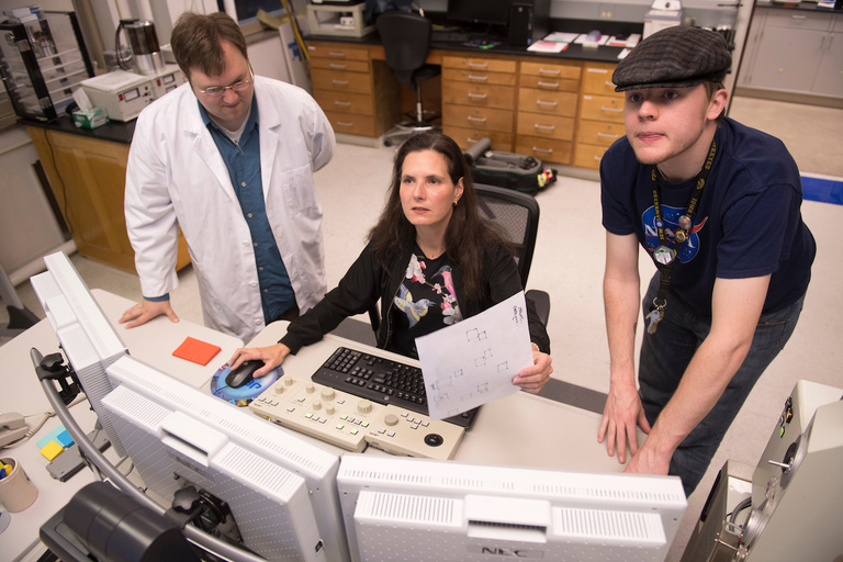 Lab manager Kenny Horkley, faculty member Ingrid Ukstins, and student Zachary Luppen use an electron microprobe to scan thin slices of meteorite to determine what elements are in the sample. Photo by Tim Schoon.