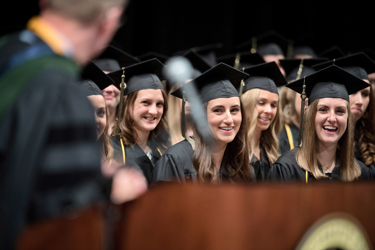 graduates smiling during commencement speech