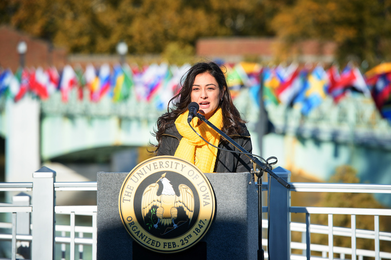 flags representing the home countries of university of iowa international students fly on the IMU footbridge; uisg president hira mustafa speaking at ceremony