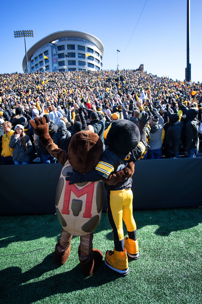 mascots embracing during the wave