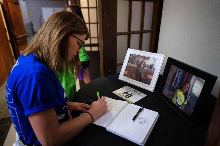 volunteer writing note in front of mollie tibbetts' photograph