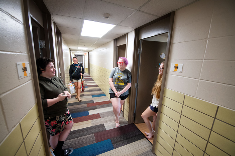 students talk outside their rooms during on iowa move-in