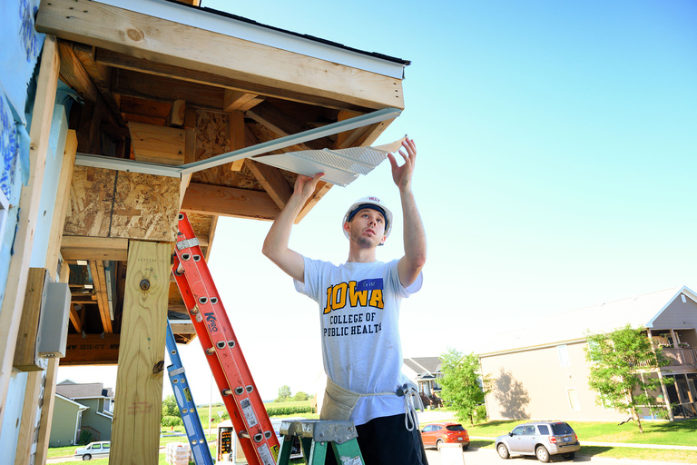 public health student working on soffit during day of service