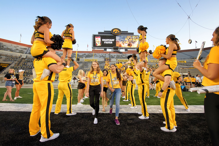 students file between cordon of spirit squad members during on iowa kickoff at kinnick