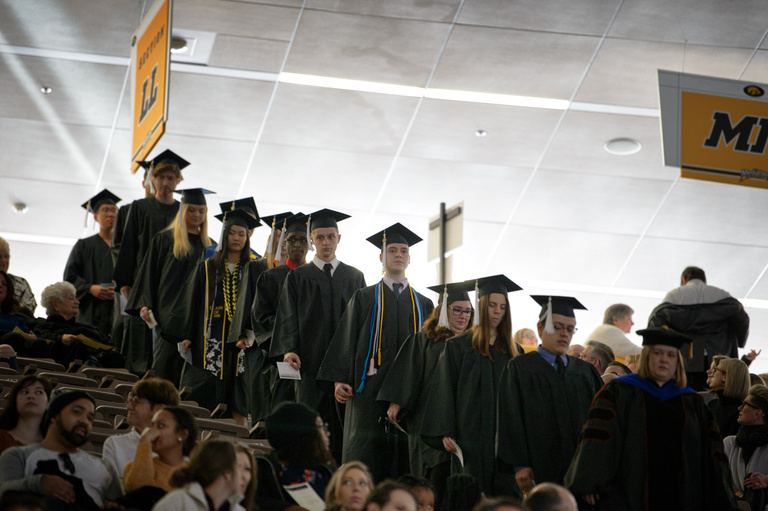 graduates walking through stands