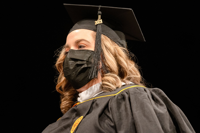 A Master's degree candidate prepares to walk to the stage during commencement. Photo by Justin Torner.