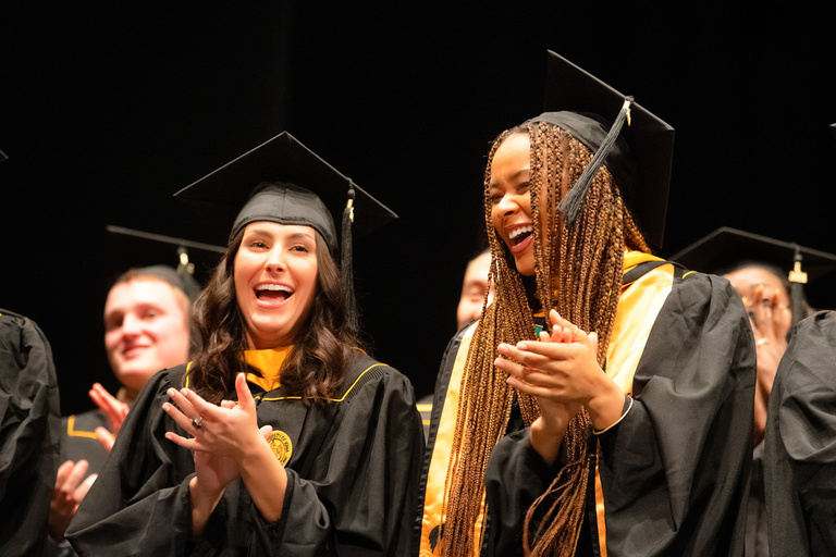 Graduates are all smiles during the Master's degree commencement ceremony. Photo by Justin Torner.