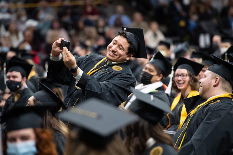 A College of Liberal Arts and Sciences student takes a selfie minutes before their ceremony begins. Photo by Tim Schoon.