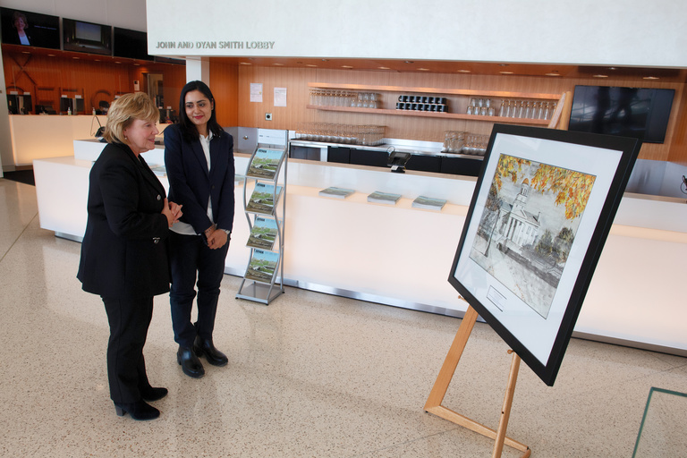 UI PhD student Gul Rukh Mehboob and President Wilson admire Mehoob's watercolor painting of the Old Capitol, which was selected as the official artwork to commemorate the university's 175 year anniversary.