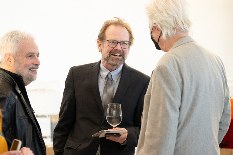 Professor Christopher Merrill talks with colleagues following the Presidential Lecture.